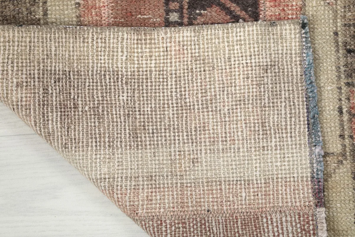 Close-up of the rug's cotton foundation, showing the tight weave and craftsmanship.