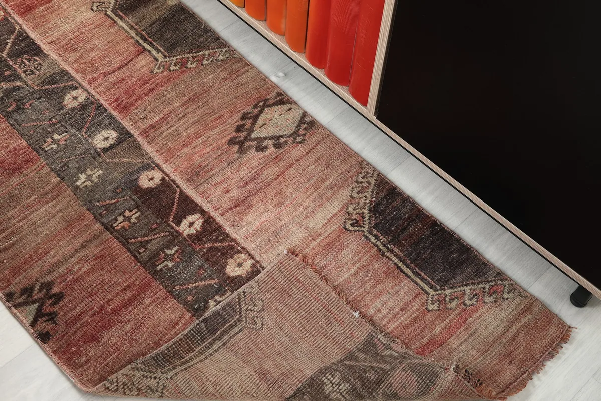 Angled view of the entire rug, illustrating the overall design and condition of the vintage piece