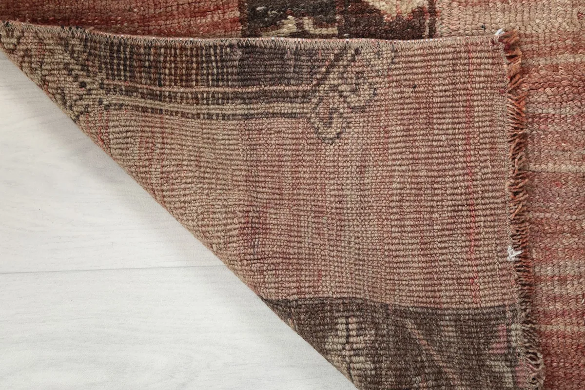 Corner of the rug folded to reveal the hand-knotted cotton foundation and reverse side
