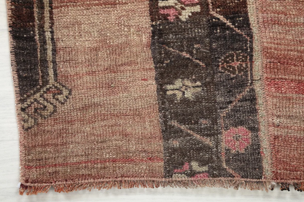 Detailed view of the rug's edge and short fringes, showing texture and color transitions