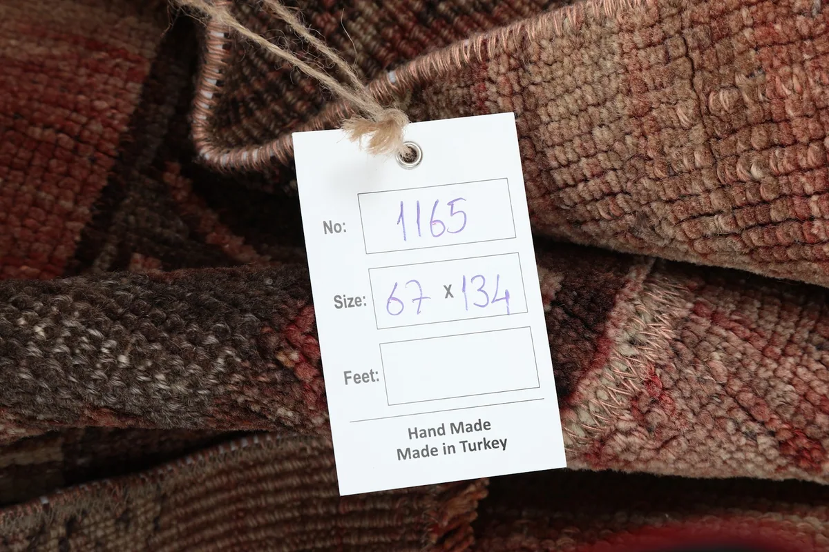Close-up of the product tag showing the rug's dimensions and 'Hand Made In Turkey' label