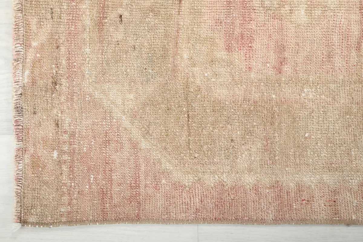 Detail of the rug's edge and fringe, showcasing the hand-knotted wool pile and cotton foundation
