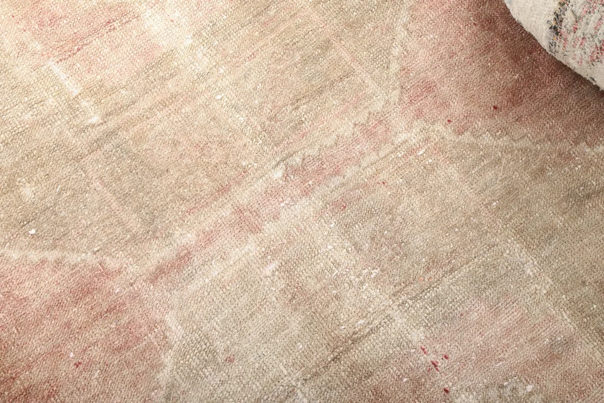 Close-up of the low wool pile, showing the distressed texture and subtle geometric design