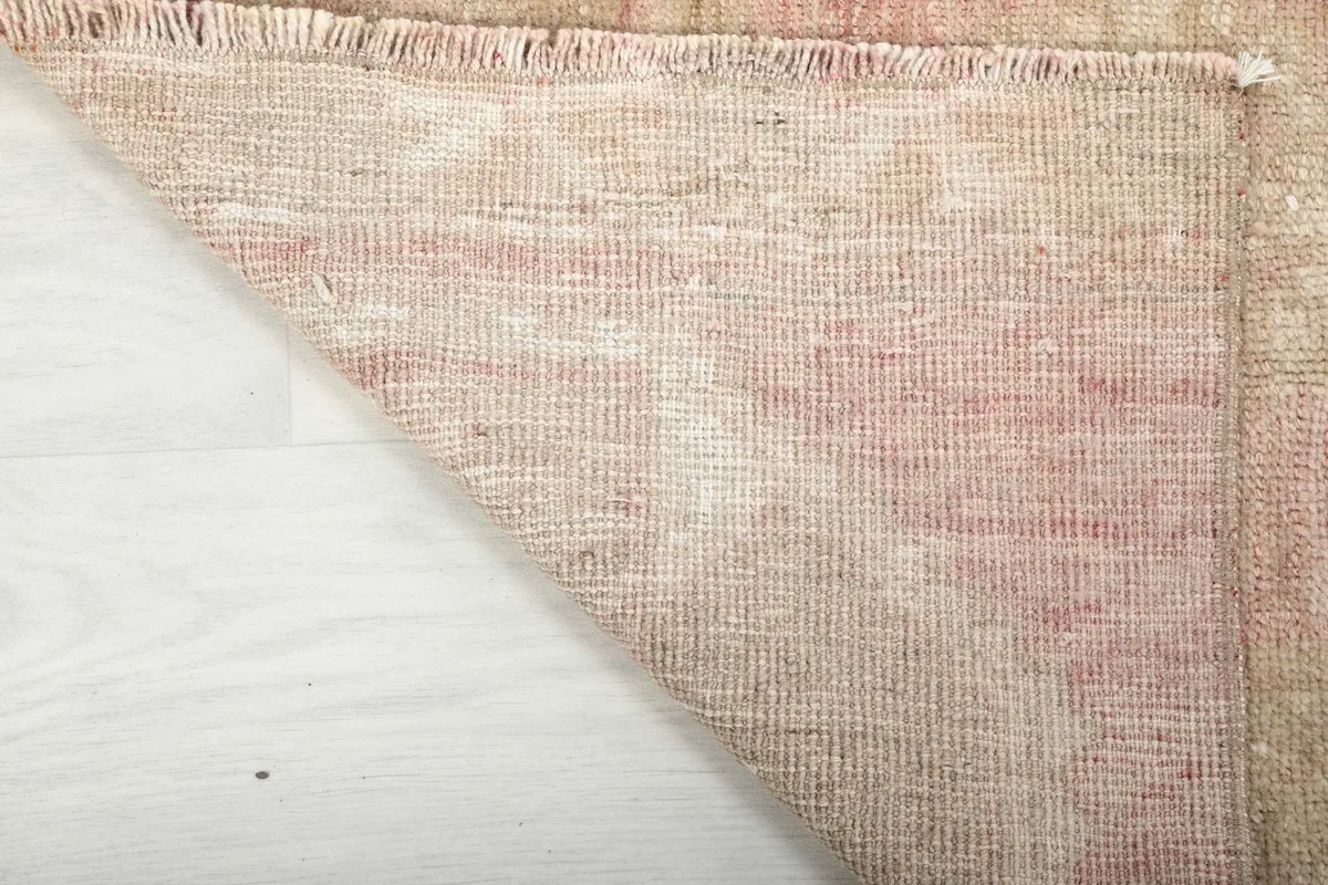 Underside view of the runner rug, showing the cotton foundation and hand-knotted construction
