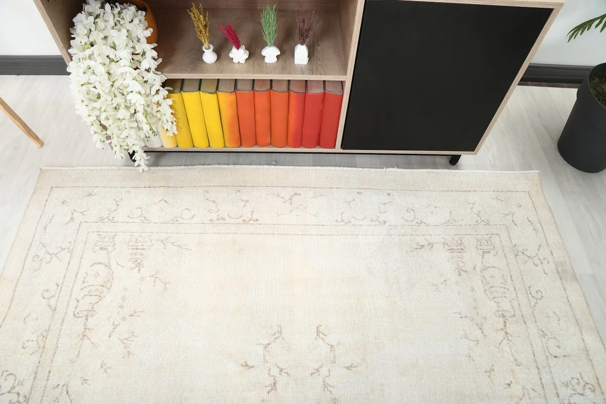 Side view of the vintage ivory rug, showing its placement under a console table