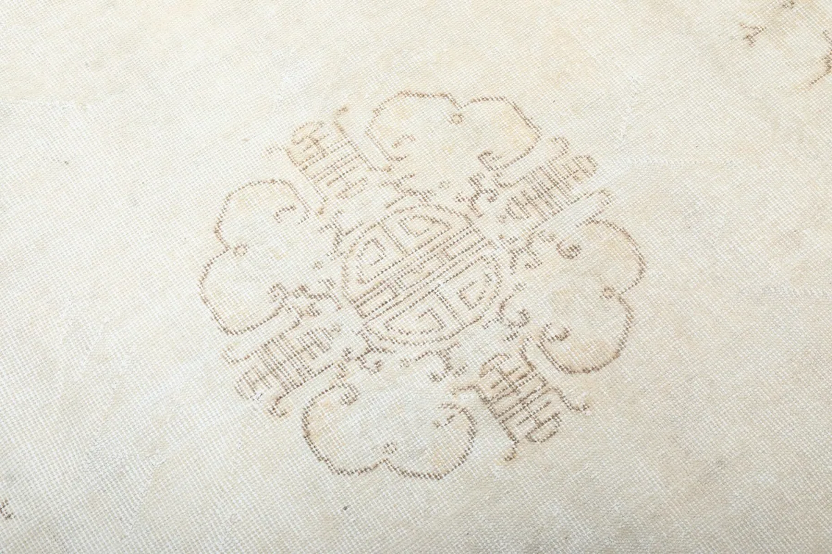 Close-up of the intricate gold and tan pattern within the central medallion of the rug