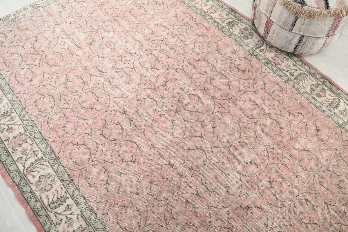 Detailed angle view of the rose rug's texture and repeating floral-geometric design