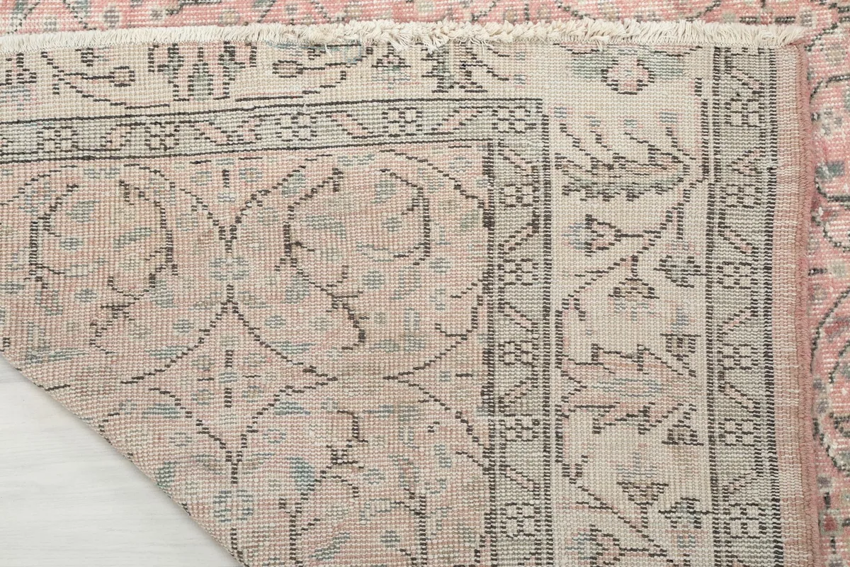Close-up of the rug's back showing the hand-knotted cotton foundation and wool pile