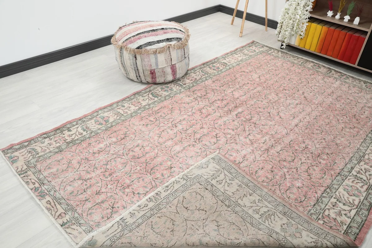 Angle view of the rose rug with a corner folded to reveal the backside and knotting