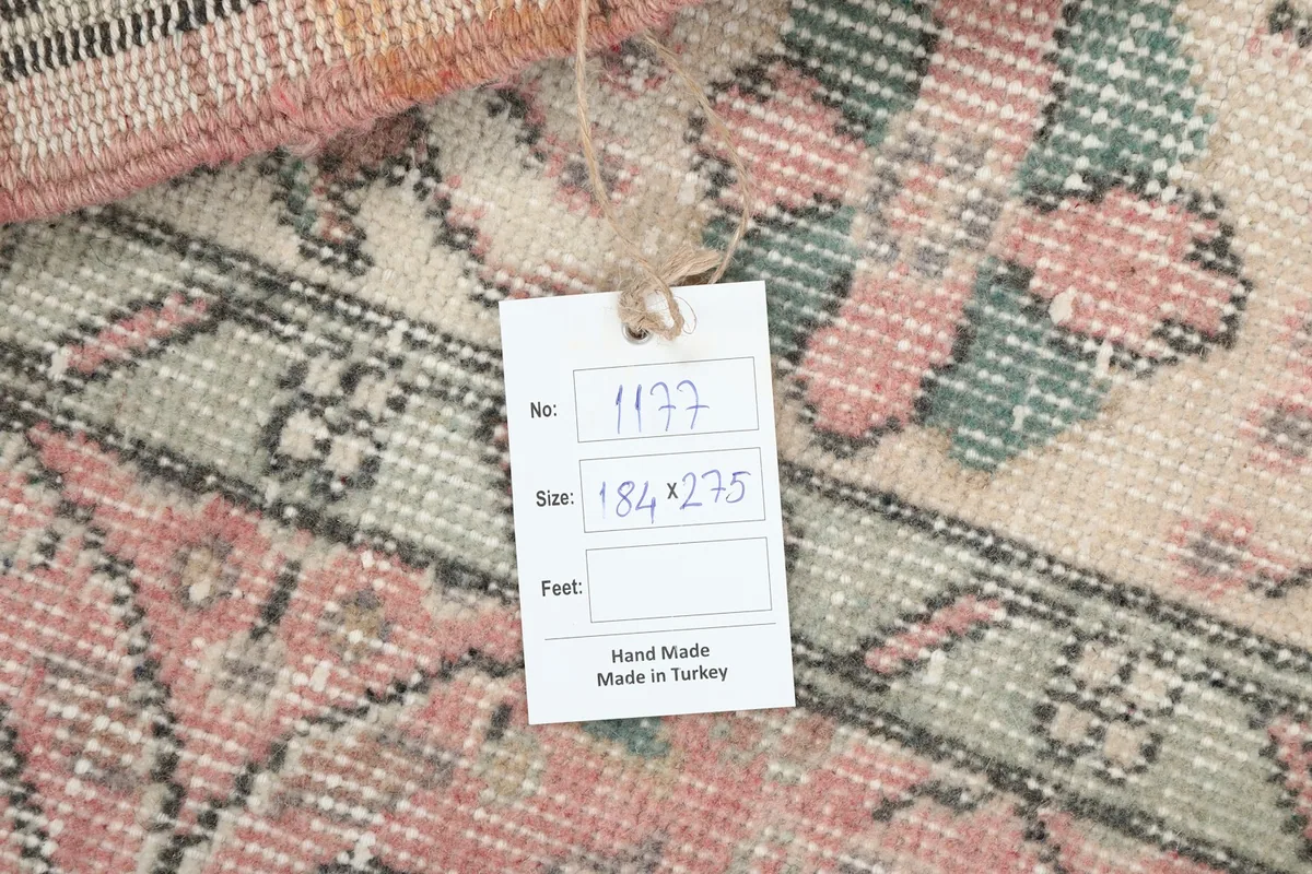 Detail of the rug's care tag, showing hand-made in Turkey and size 184x275 cm