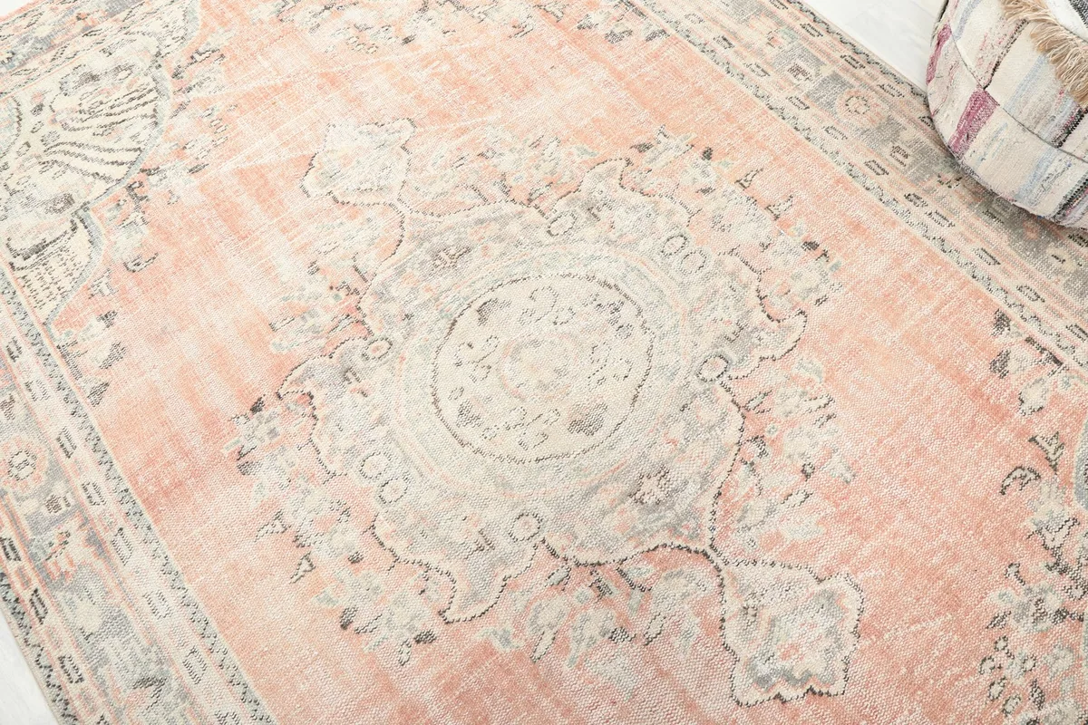 Detailed shot of the central medallion and surrounding patterns in rose and gray