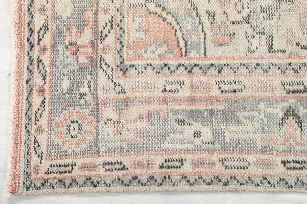 Detailed view of the rug's border design with geometric and floral elements
