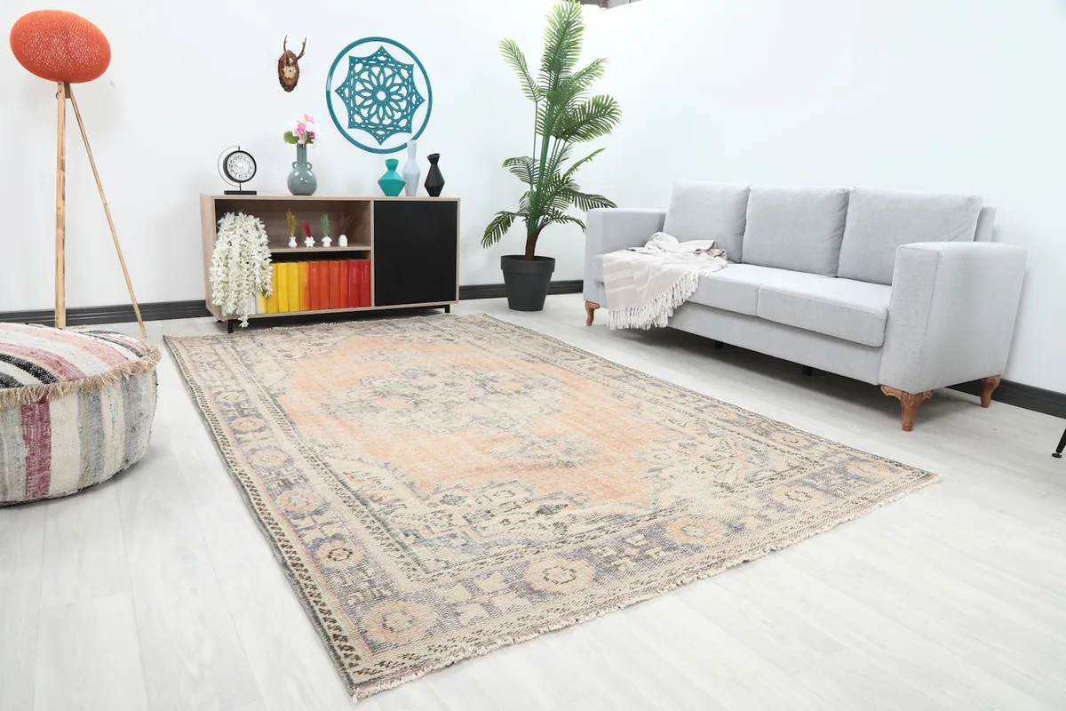 Another angle of the rust and gray vintage area rug in a living room with a gray sofa