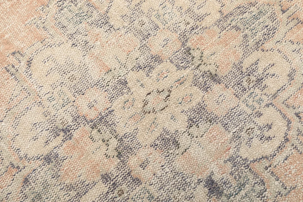 Texture and low pile detail of the hand-knotted wool rug, showing natural wear