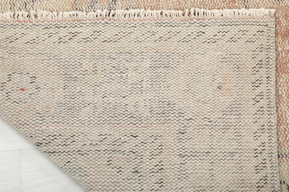 Close-up of the back of the rug, revealing the knotting and fringe