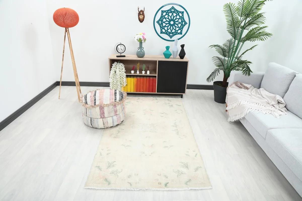 Beige vintage rug in a living room setting with a light gray sofa and modern decor