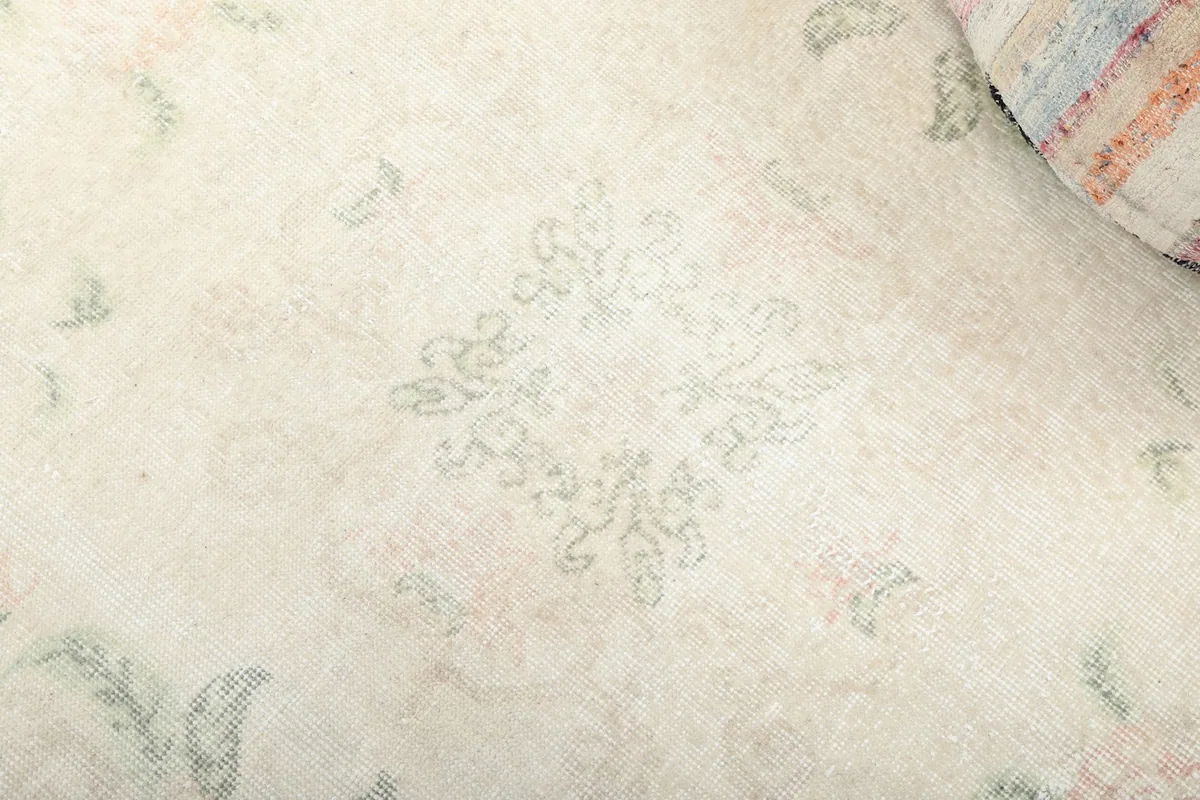 Close-up of the central geometric medallion motif and surrounding floral details on the rug