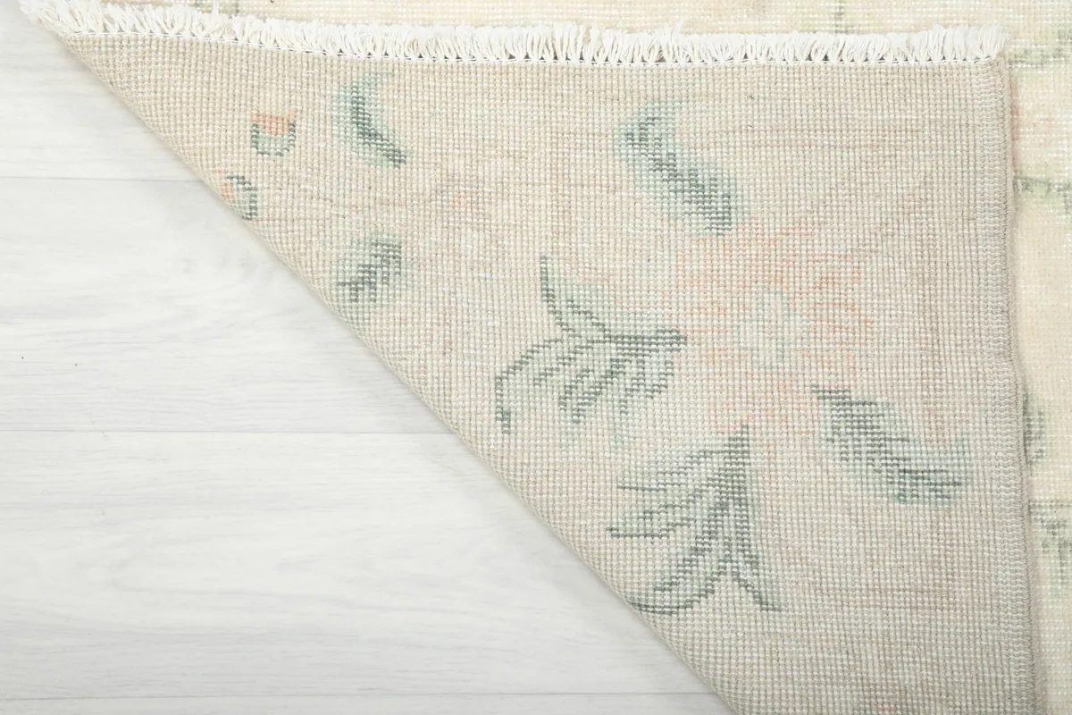 Underside of the rug's corner, showing the tightly woven cotton foundation and knotting