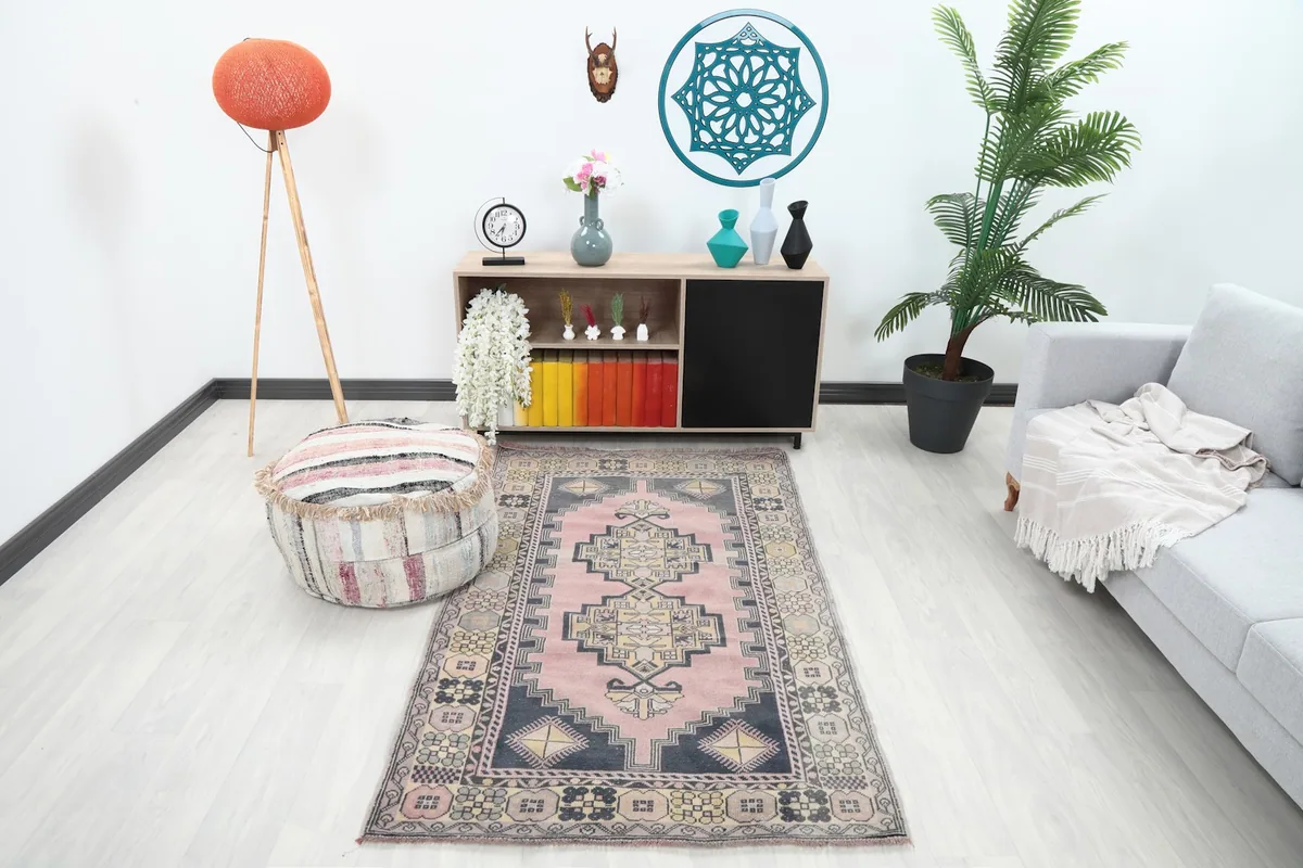 Vintage rose and navy rug displayed in a bright living room setting with modern furniture and decor