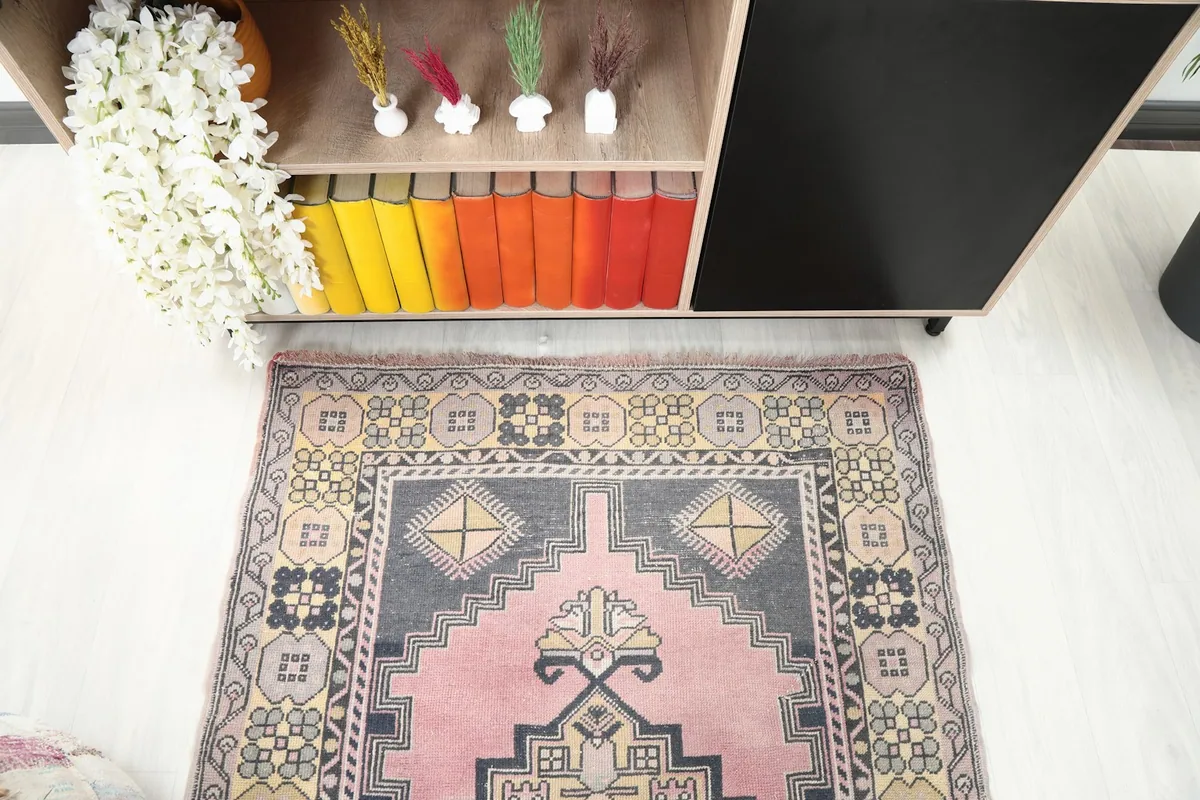 Detail of the rug's top section in a room setting, showing the intricate border patterns and colors