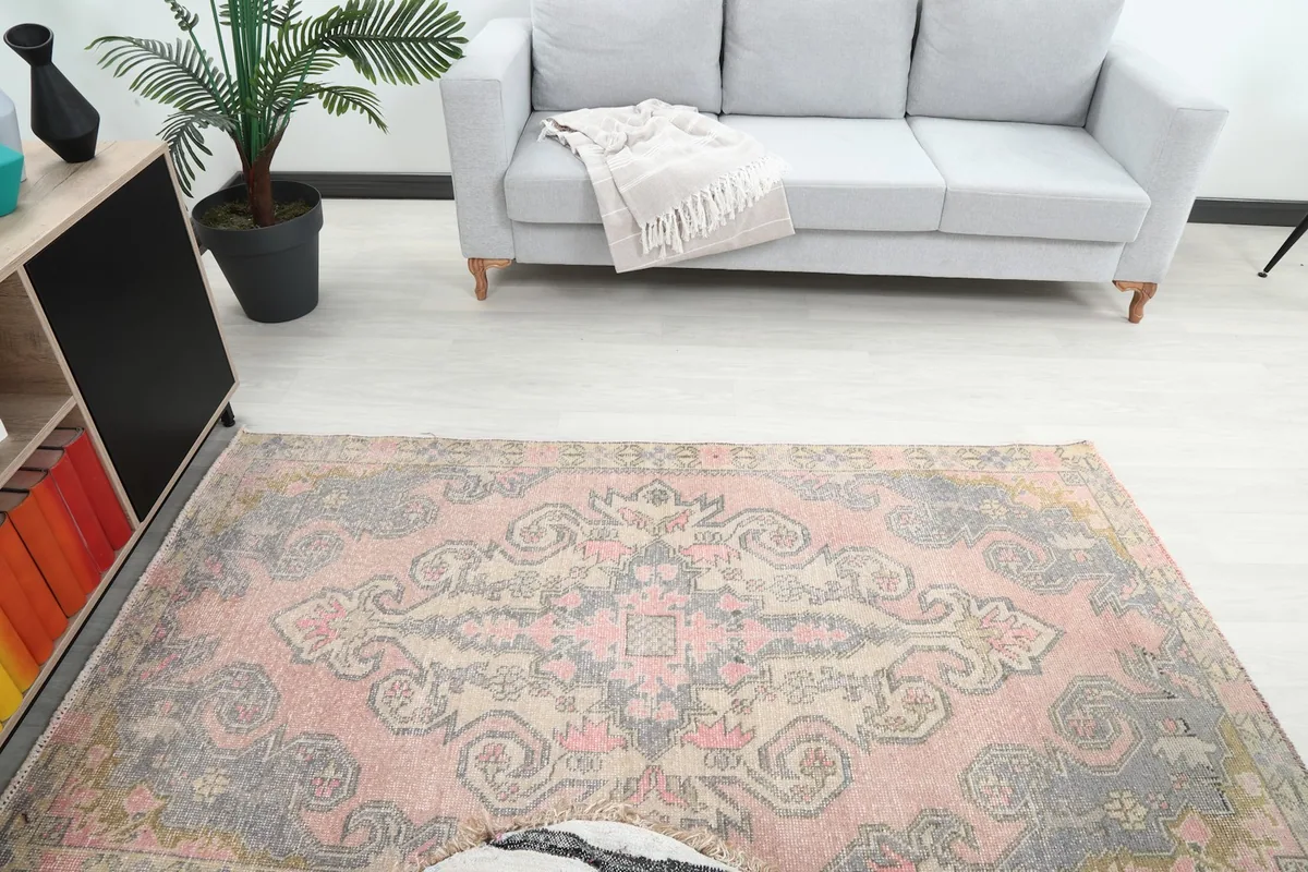 Overhead view of the vintage rug in a room, highlighting the central medallion and overall color scheme.