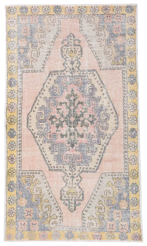 Full top view of the vintage Anatolian rug with a rose field, yellow border, and blue geometric medallion