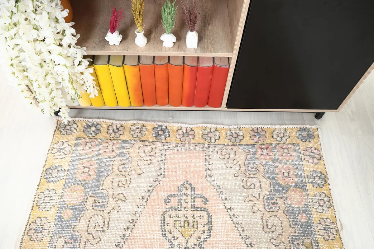 Detail shot of the rug's top portion and border in a room, highlighting the yellow floral design