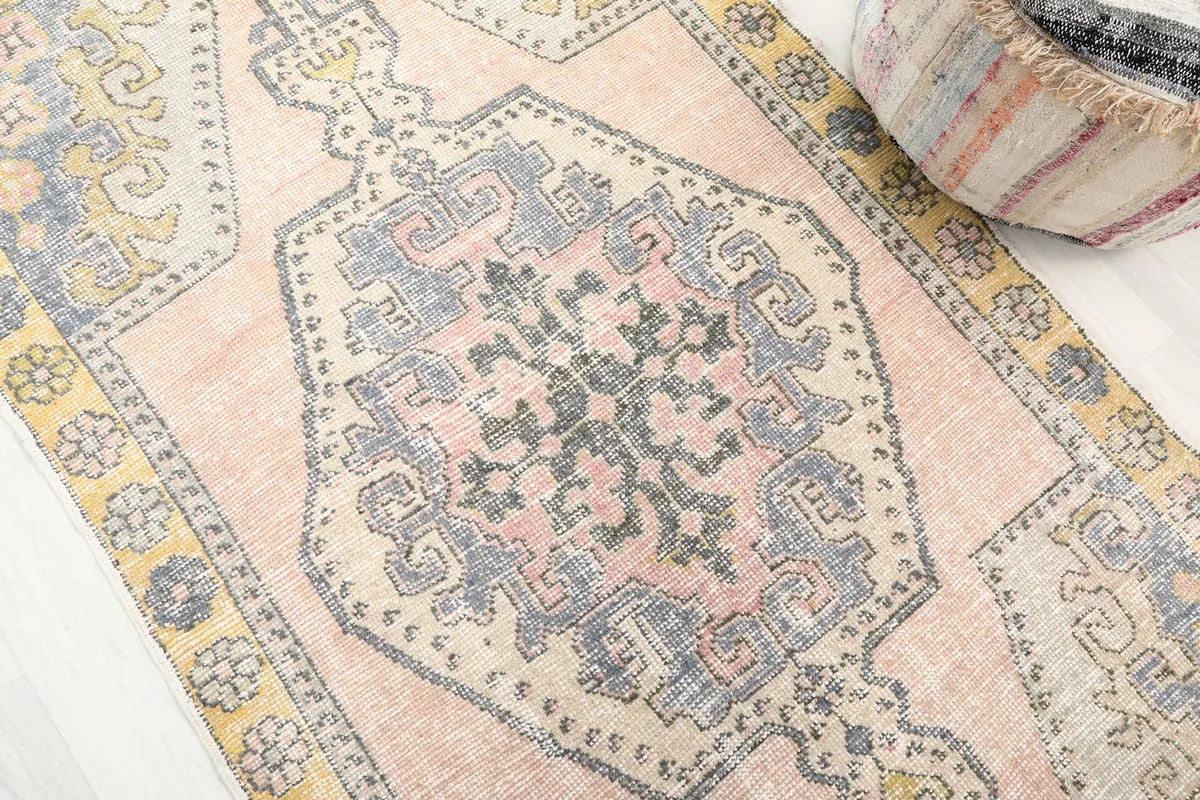 Close-up of the central geometric medallion with blue, gray, and black motifs on the rose field