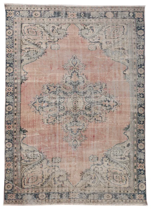 Full overhead view of the vintage rose and navy Anatolian area rug on a white background