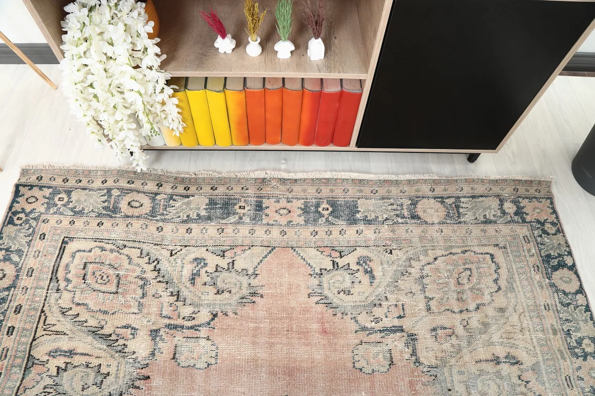View of the rug's border and a corner of the main field, next to a bookshelf