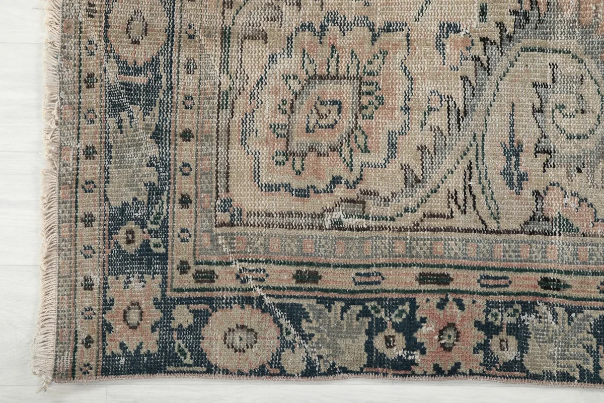 Close-up of the navy border design with floral and geometric motifs, and the fringe