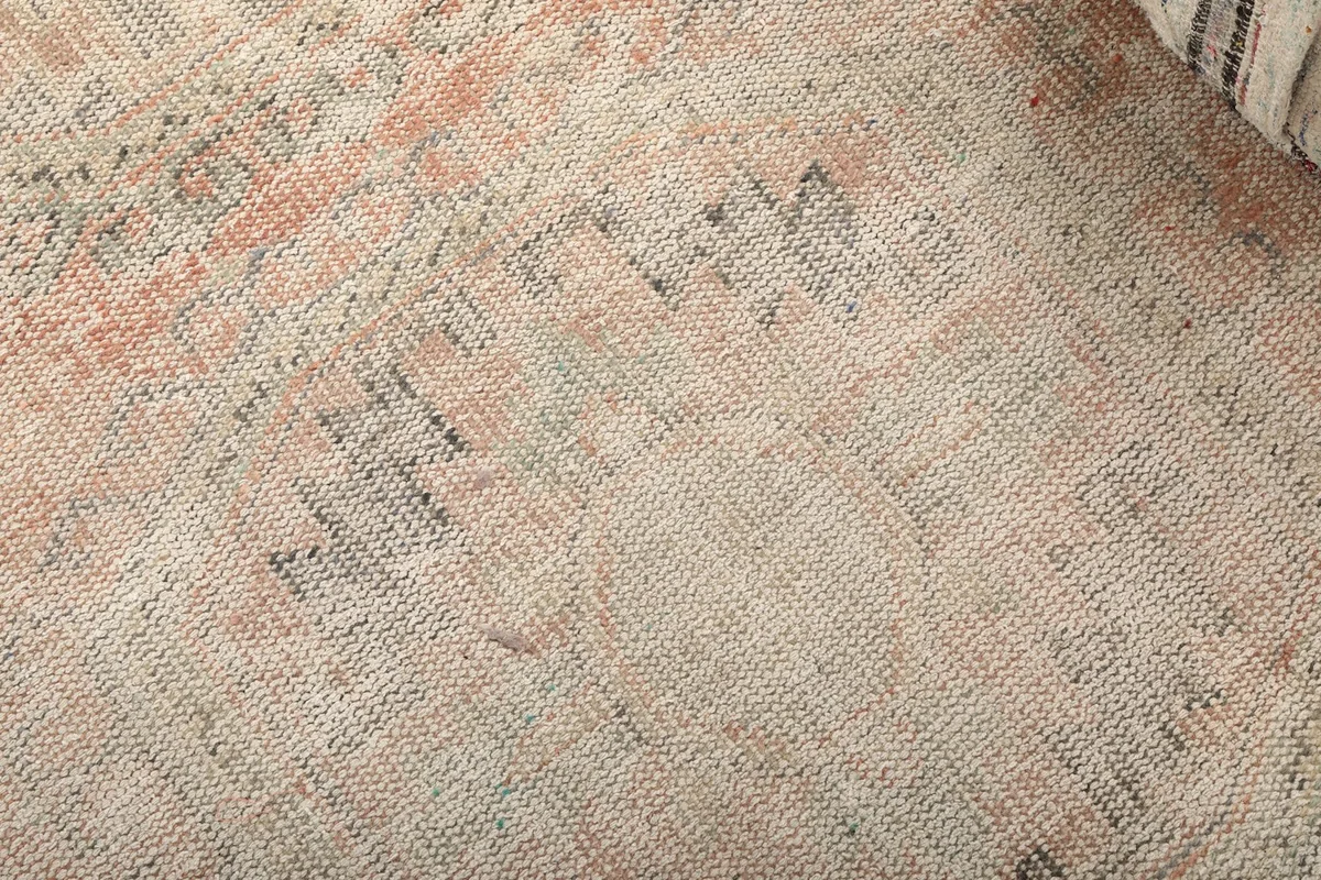 Close-up detail of the hand-knotted wool pile, showing the distressed geometric patterns and colors.