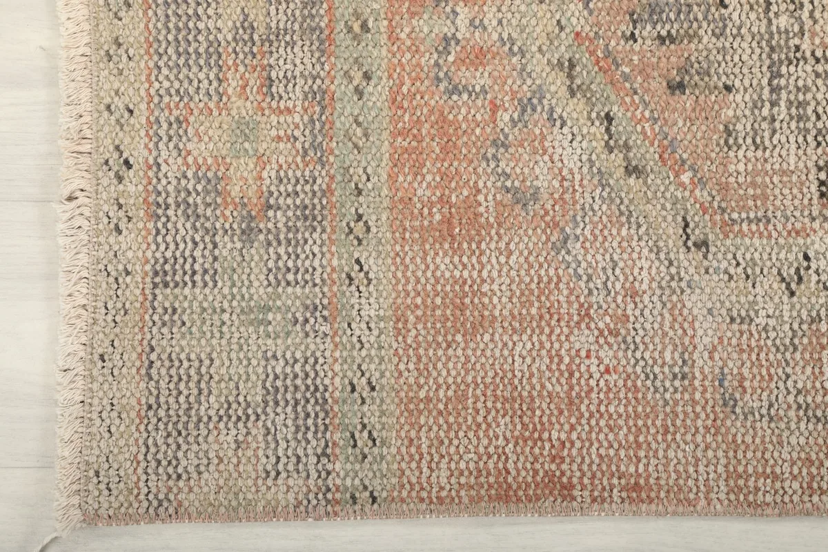 Detail of the rug's edge and fringe, highlighting the construction and color transitions.