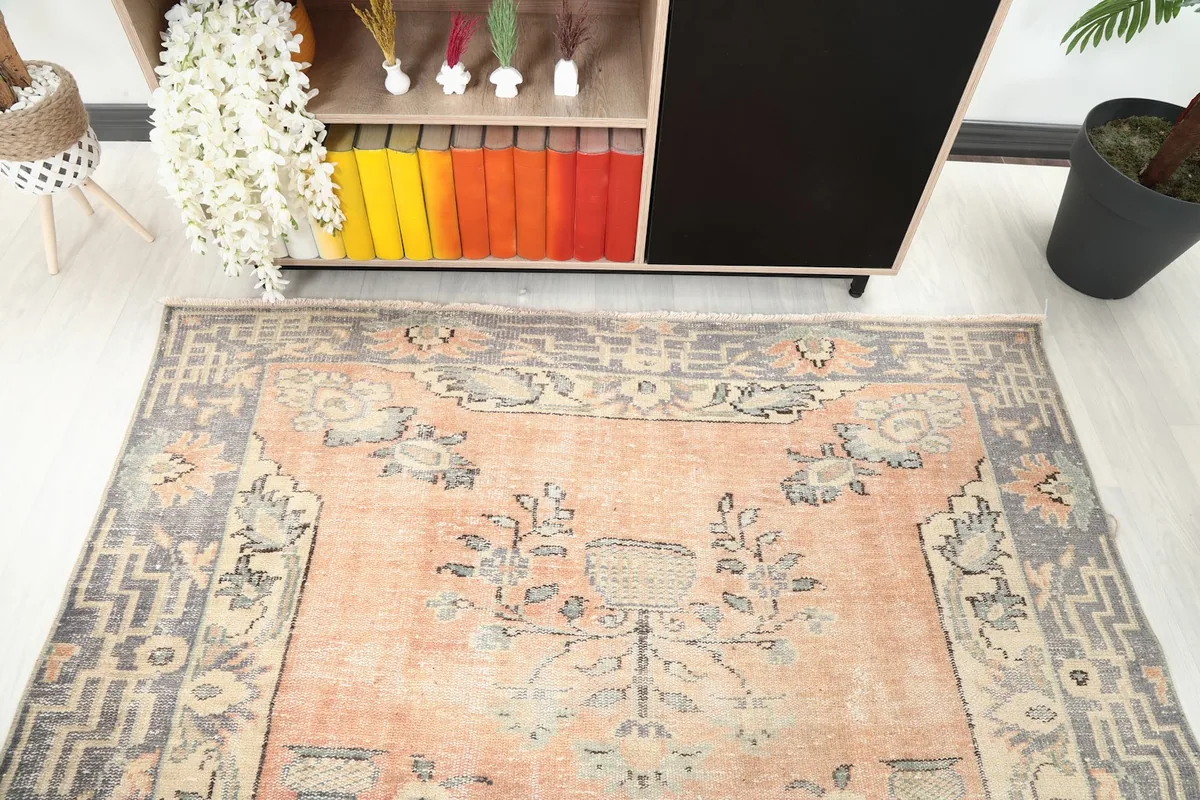 Angled view of the rug's upper section, highlighting the floral motifs and soft orange tones