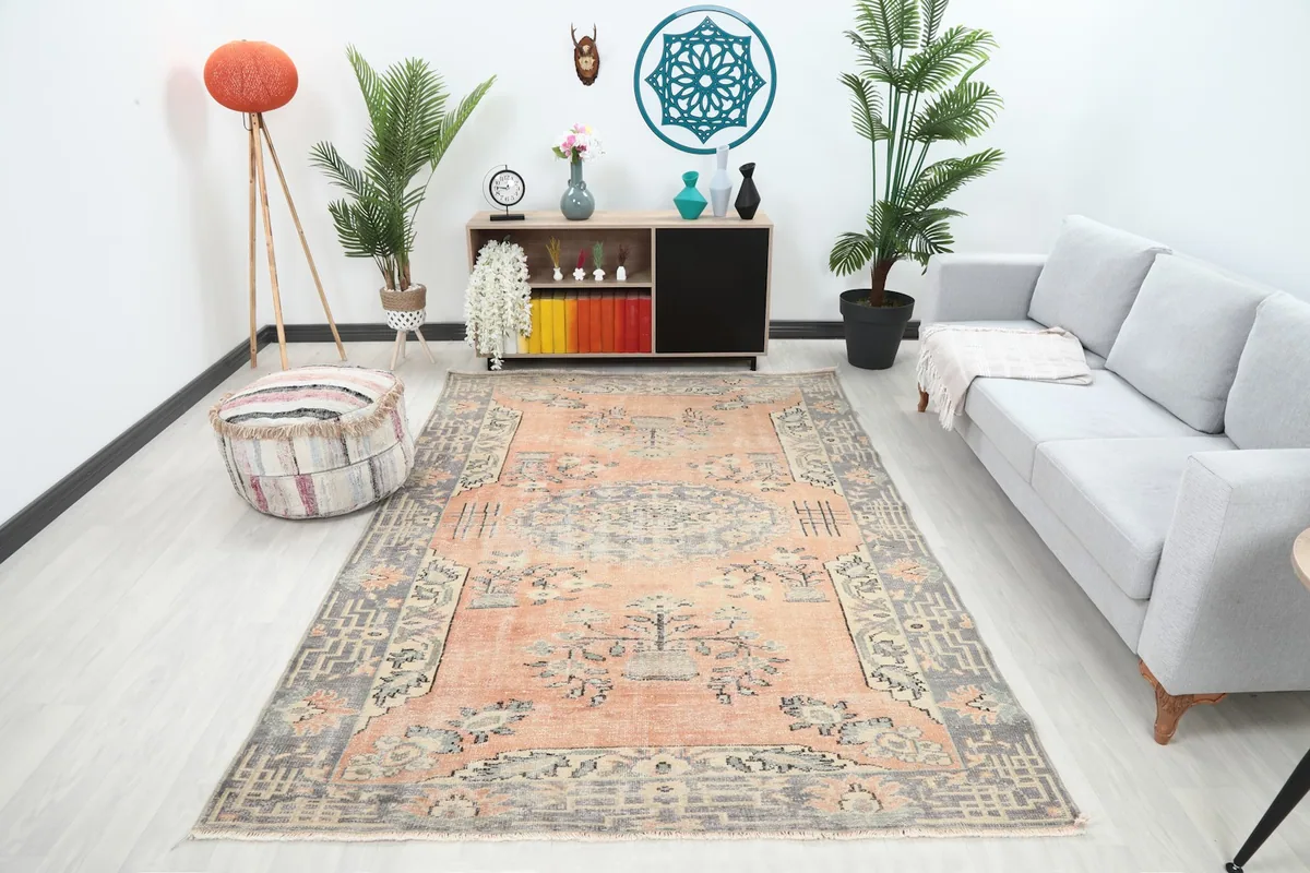 Vintage Anatolian rug displayed in a living room setting with a gray sofa and modern decor