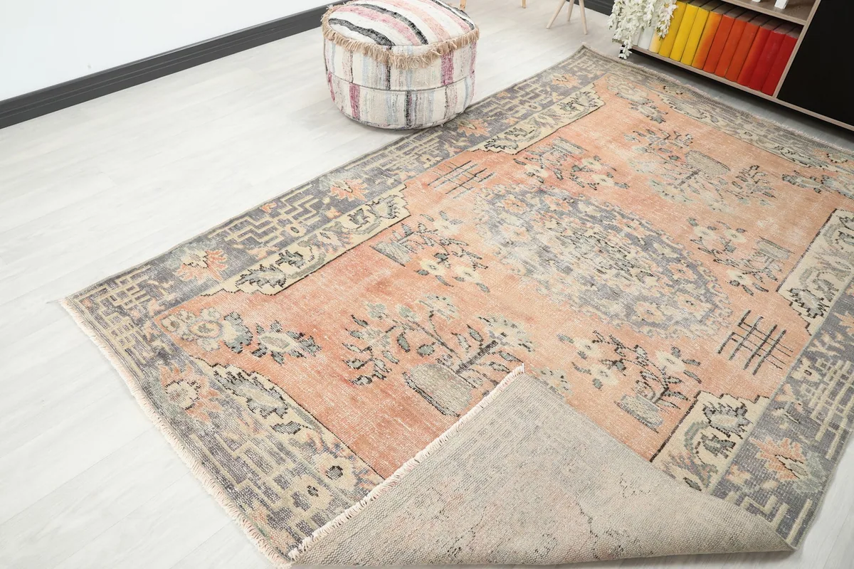 The vintage rug partially folded, revealing the cotton foundation and showing the full design