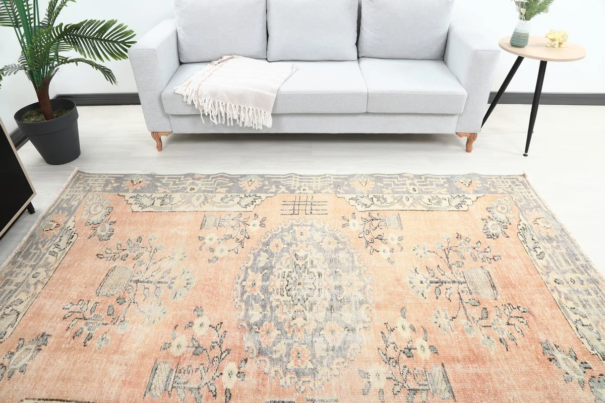 Overhead view of the vintage rug in a room, showing its full length in front of a gray sofa