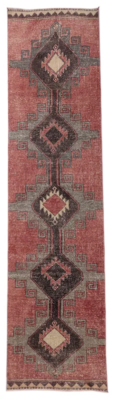 Full overhead view of the rust and charcoal tribal runner rug on a white background.