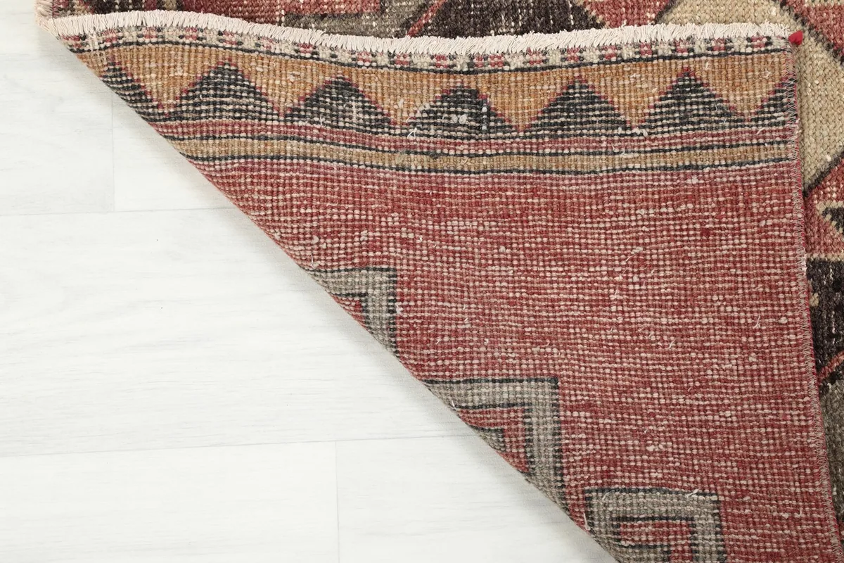 Underside of the runner rug, displaying the hand-knotted cotton foundation and wool knots.