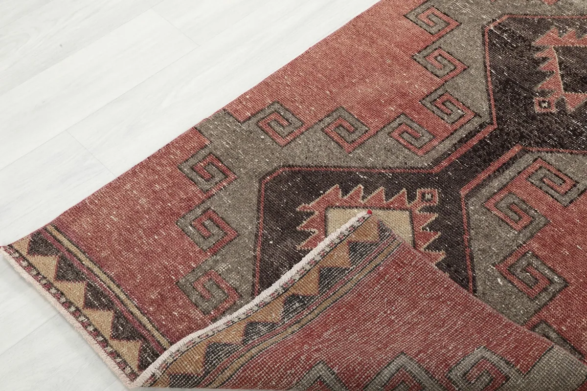 Corner of the runner rug folded back, showcasing the reverse side and construction.