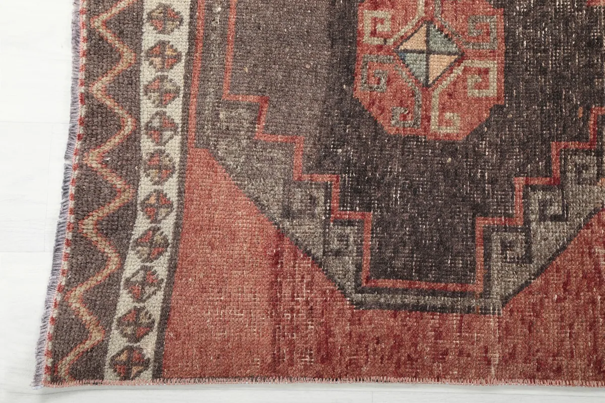 Close-up of the rug's border and a portion of the main field, showing the edge design and patina.