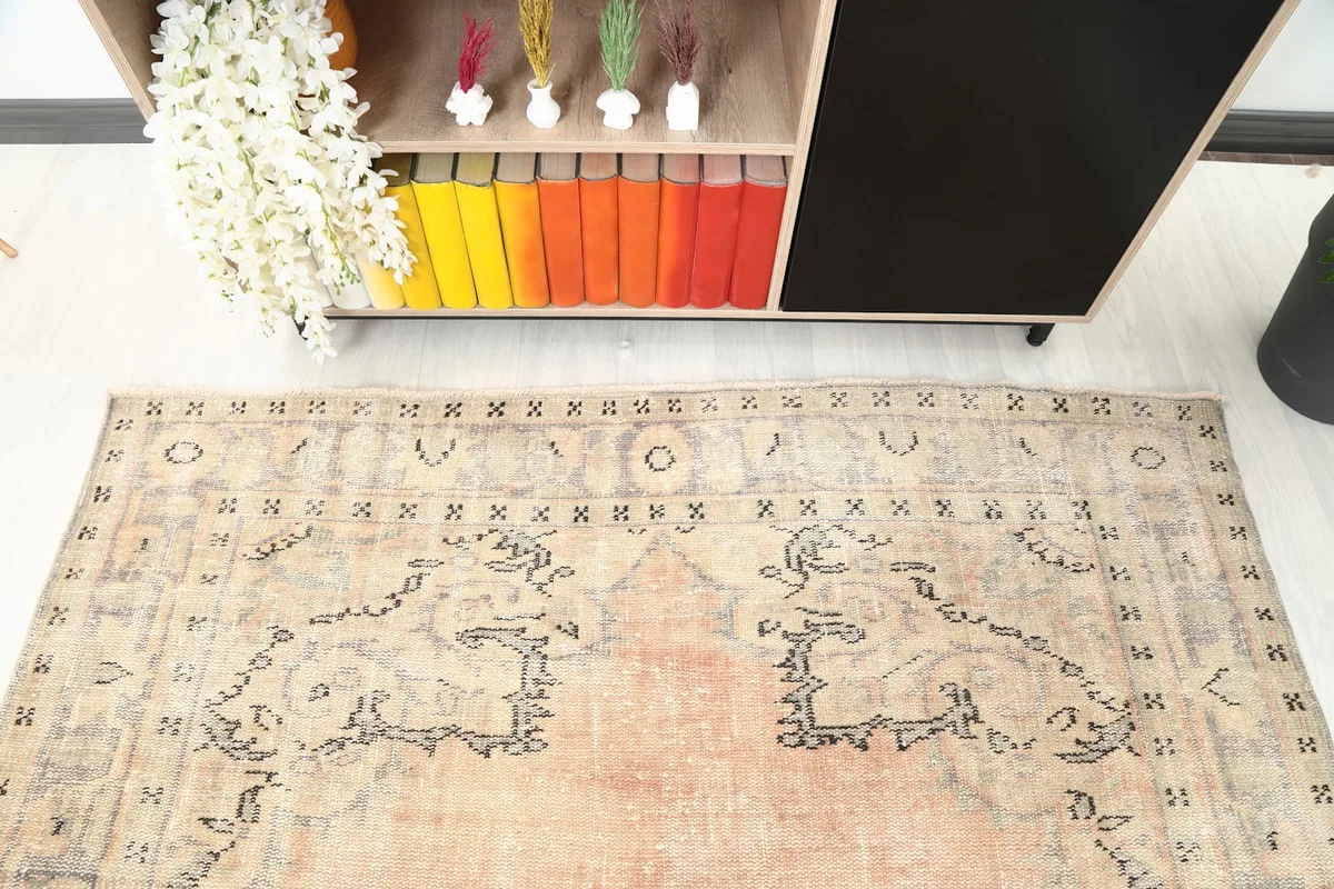 Detailed view of the rug's patterns and colors near a bookshelf with colorful books