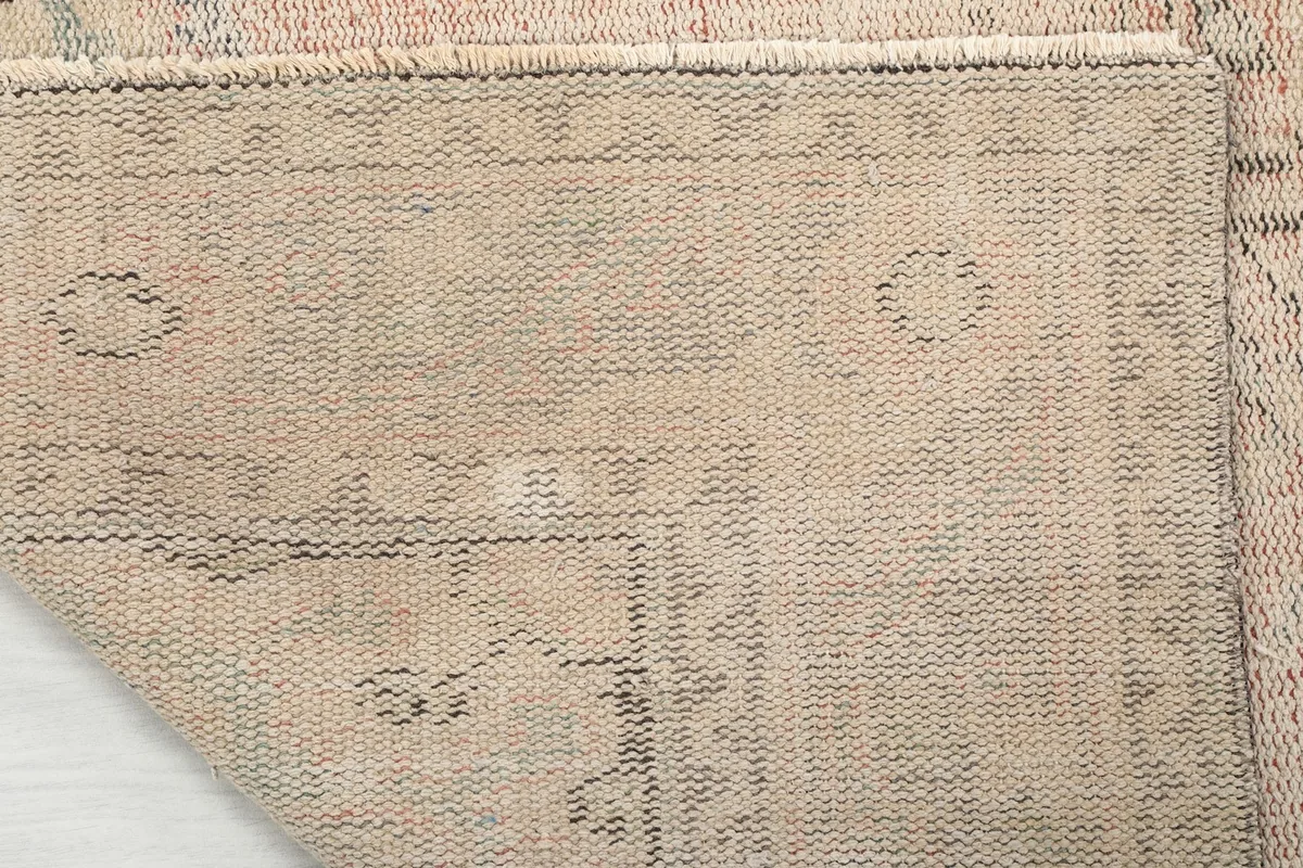 View of the back of the rug, showing the tight hand-knotted weave and cotton foundation