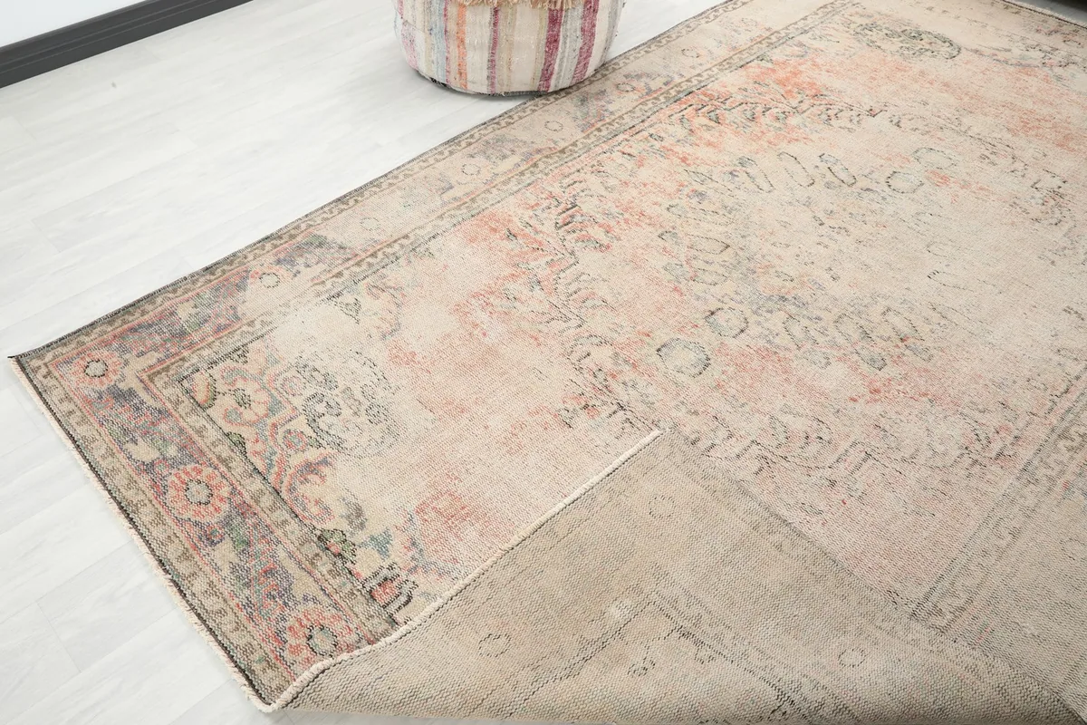 Corner of the rug folded back, revealing the cotton foundation and hand-knotted construction