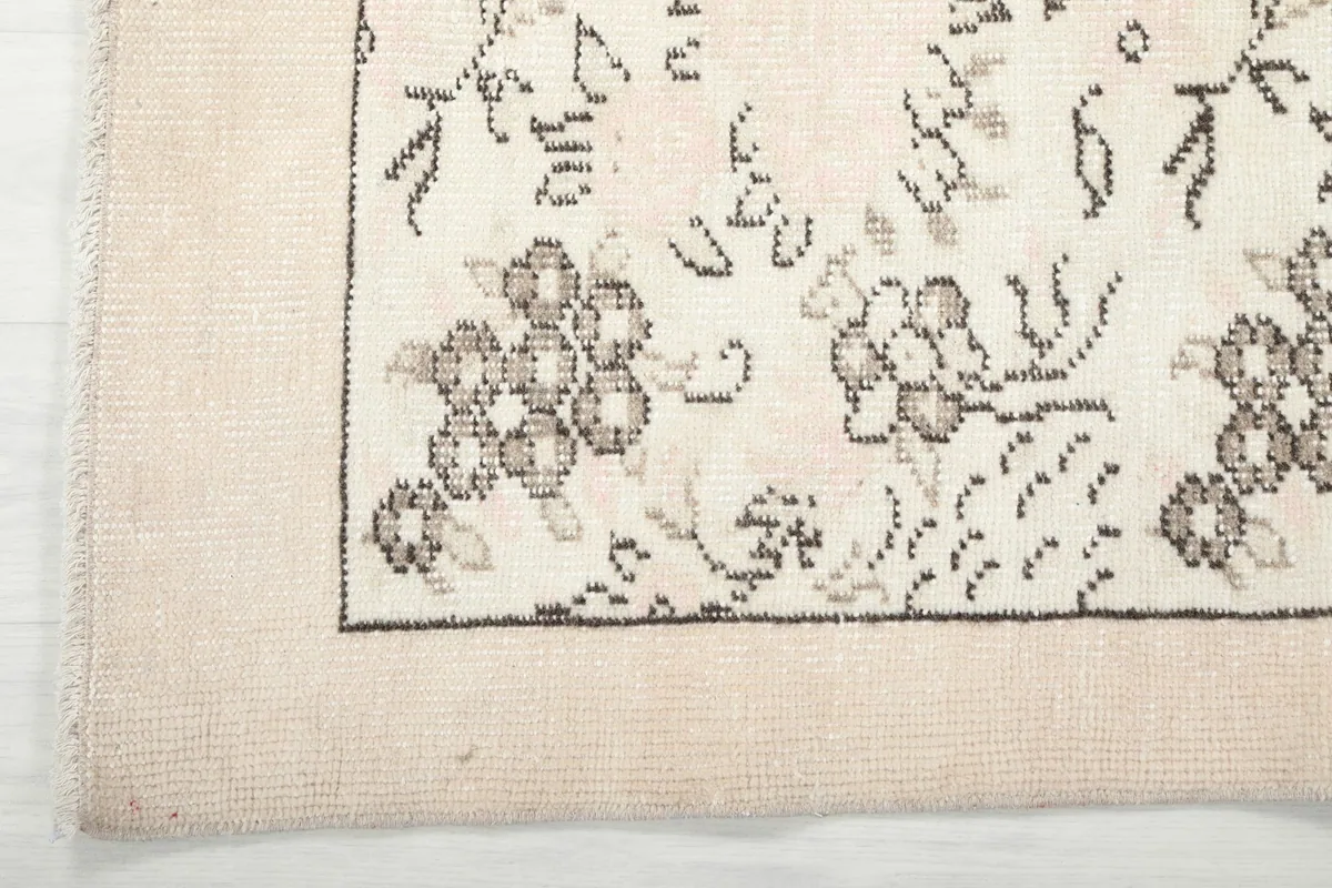 Corner detail of the ivory rug, showing the clean border and edge finishing