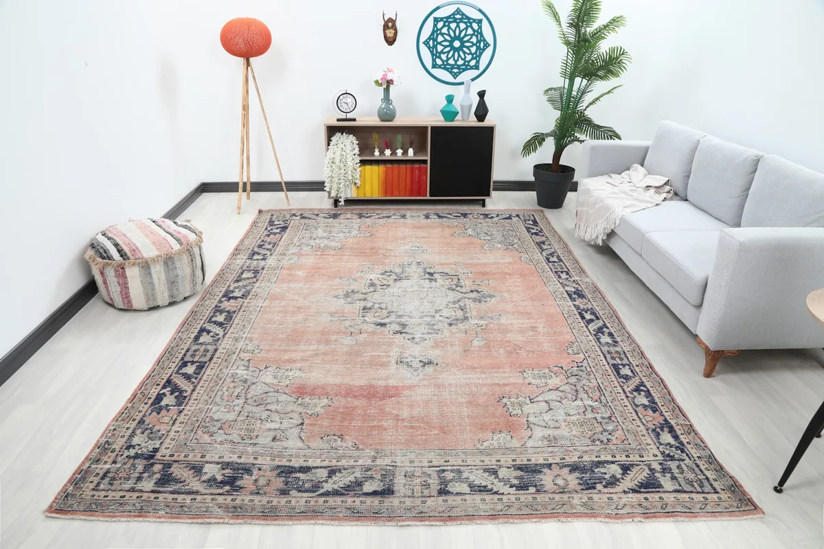 Large rose and navy vintage rug placed in a modern living room setting.
