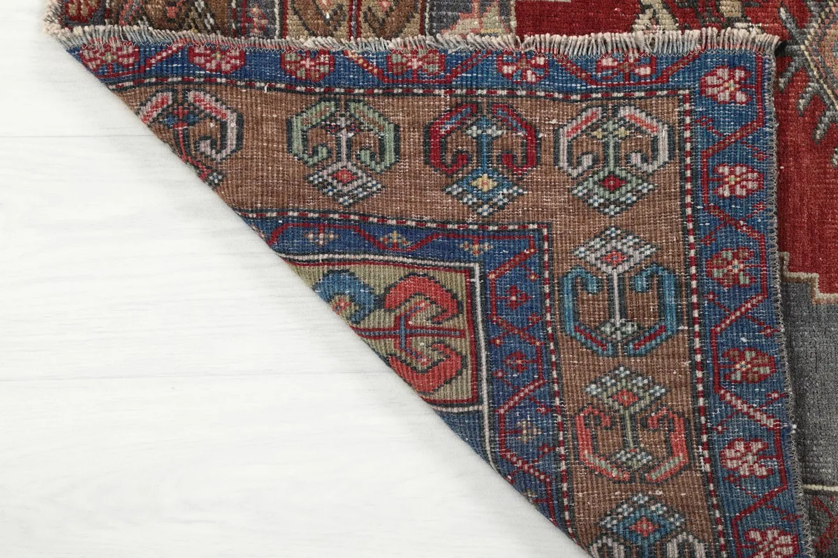 Underside corner of the rug revealing the hand-knotted cotton foundation and wool pile