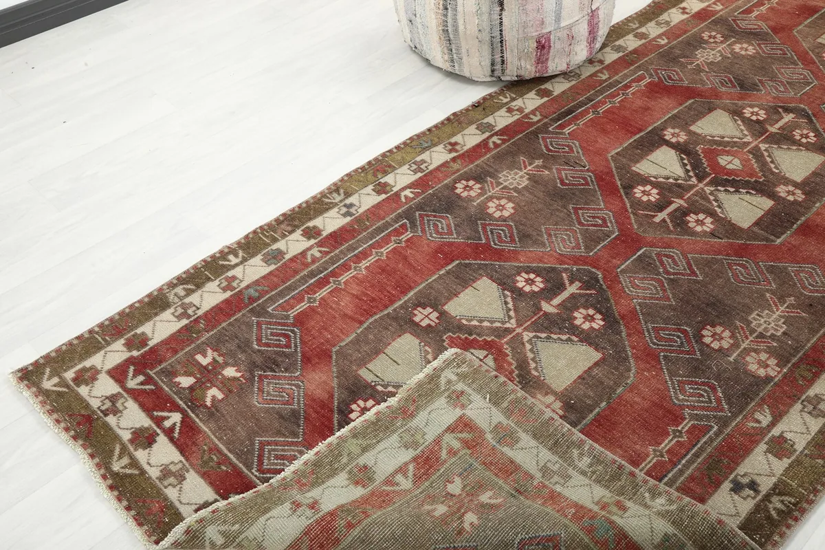 Angled view of the runner rug with a corner slightly folded, revealing the reverse side of the weave