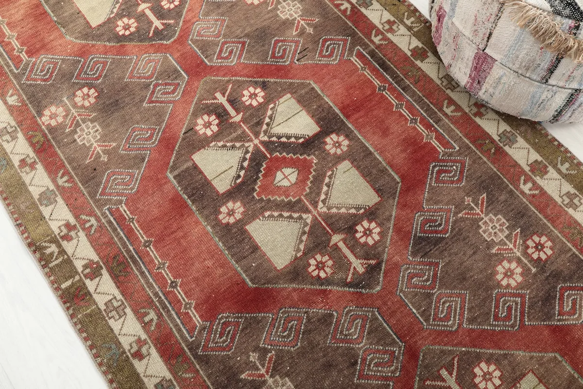 Detailed view of the runner's central geometric pattern, including red, brown, and beige tones