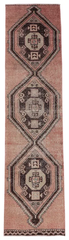 Full overhead view of the rose and brown geometric Anatolian runner rug on a white background